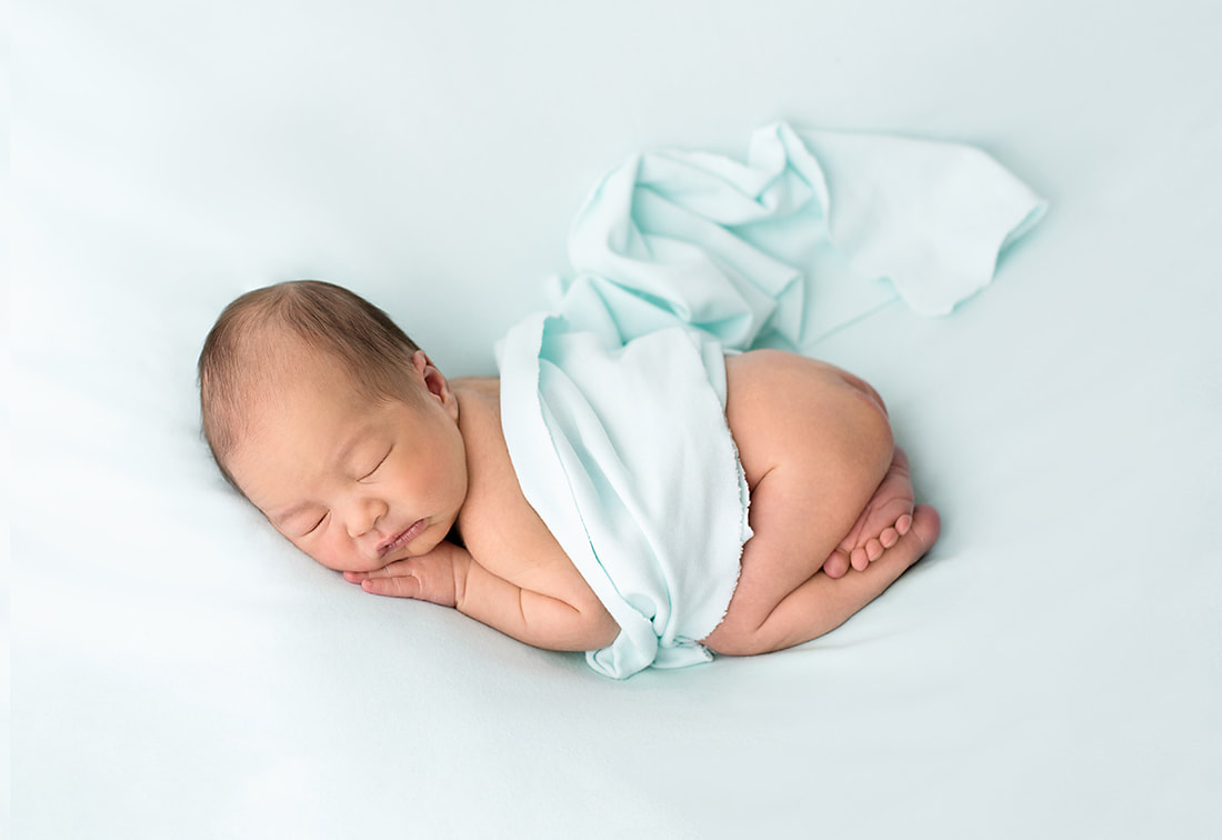 Baby boy lay on blue blanket in photography studio Cheadle