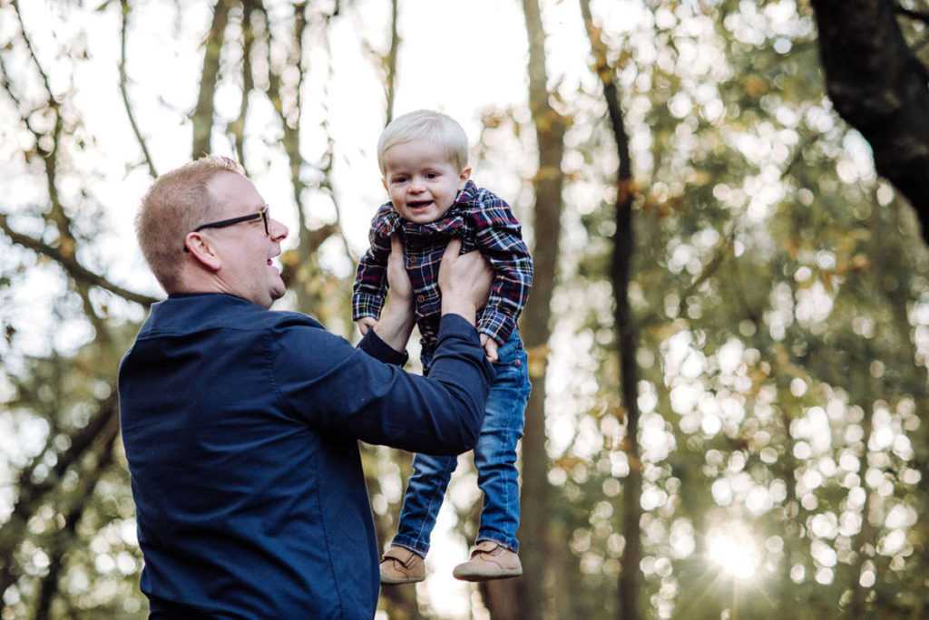 Father and son playing in the Autumkn sun during a family photography session