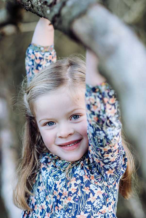 Photograph of girl playing in trees by professional photographer