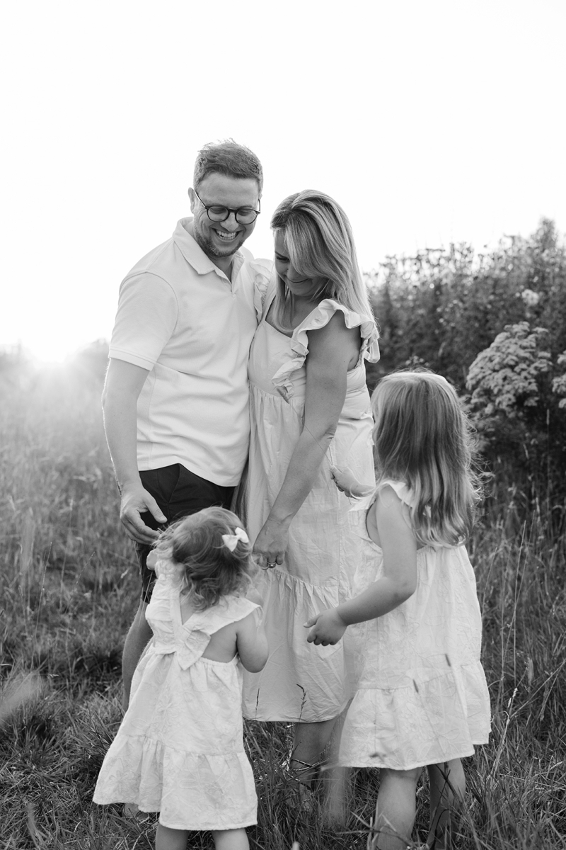 Family of four laughing and playing in a field-Didsbury Family Photographer